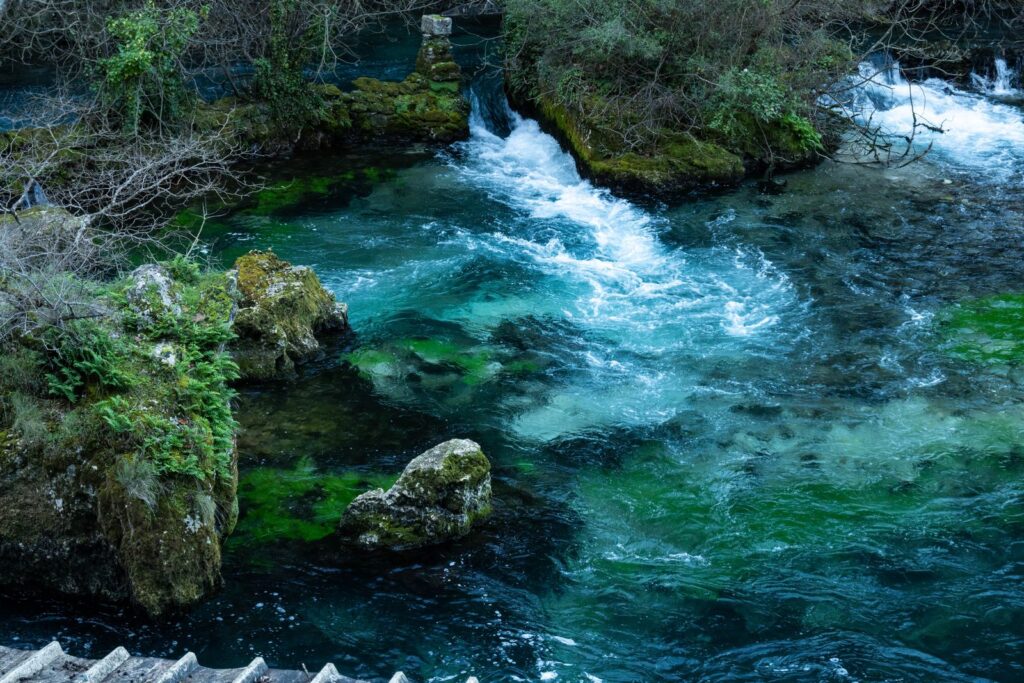 L'eau vert émeraude de la Sorgue dévale entre les rochers à Fontaine-de-Vaucluse.